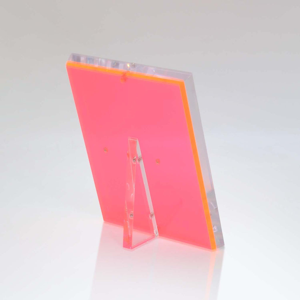 Vibrant neon pink acrylic stand shines against gradient white background.