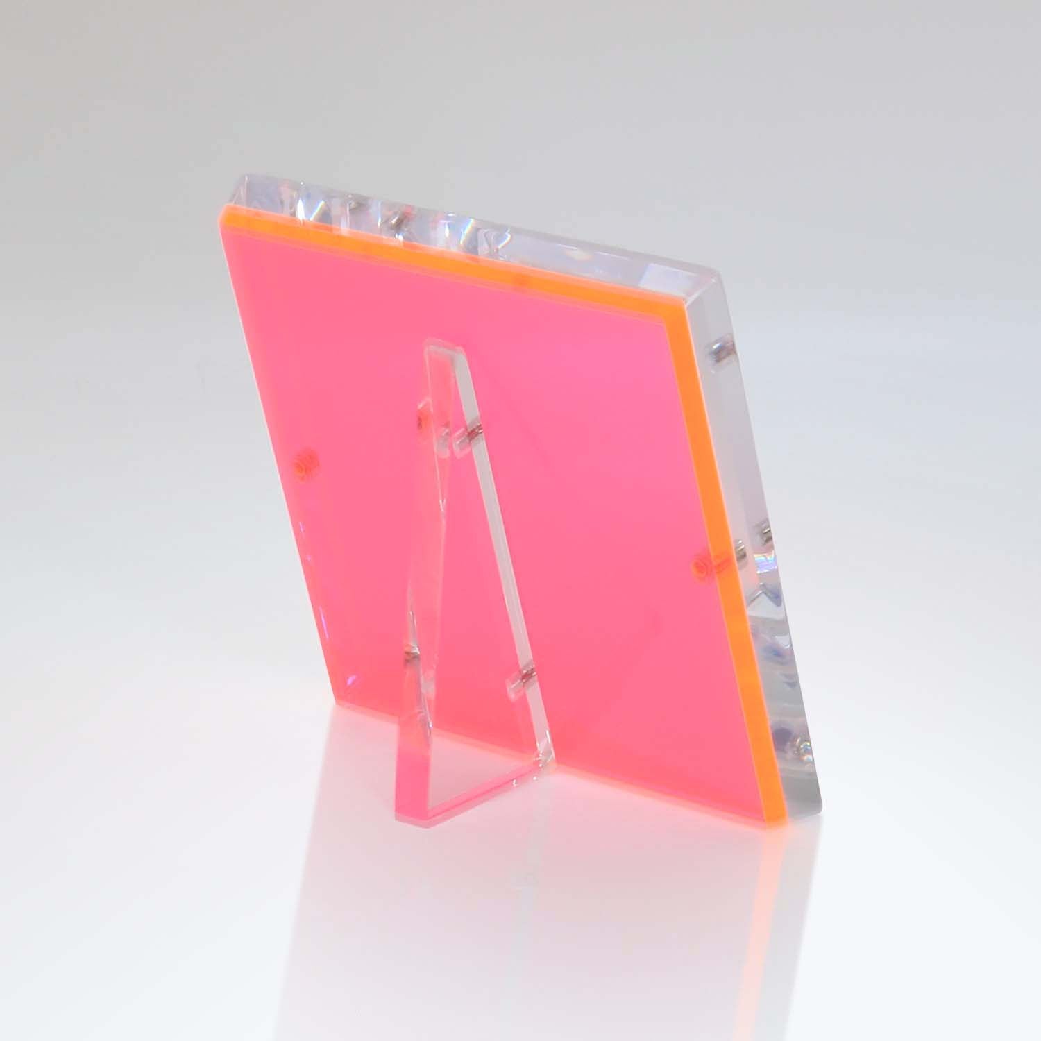 Neon pink acrylic sign holder in modern L-shape design.