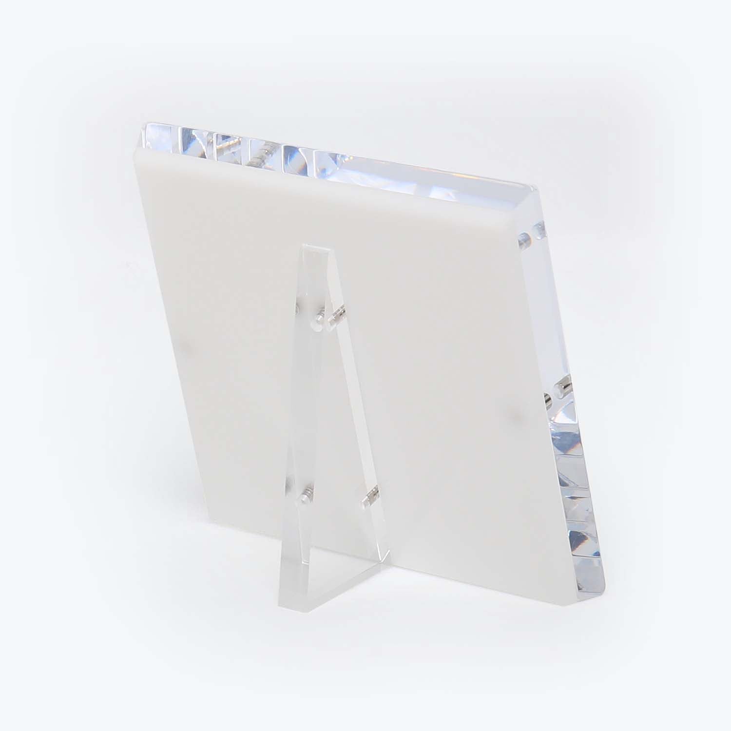 Modern acrylic photo frame with faceted design, displayed on white.