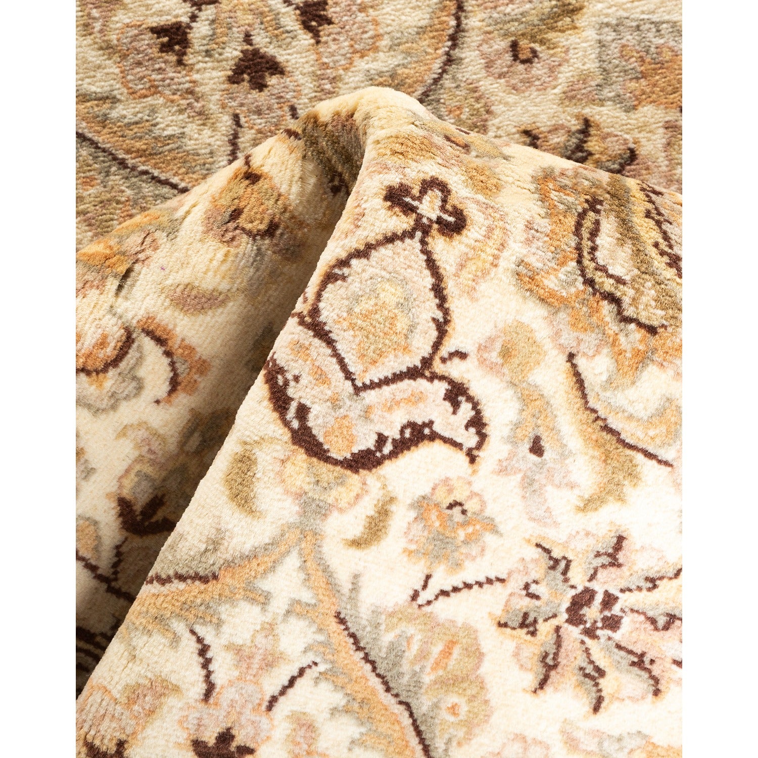 Soft-toned, plush rug with intricate floral pattern folded for display.