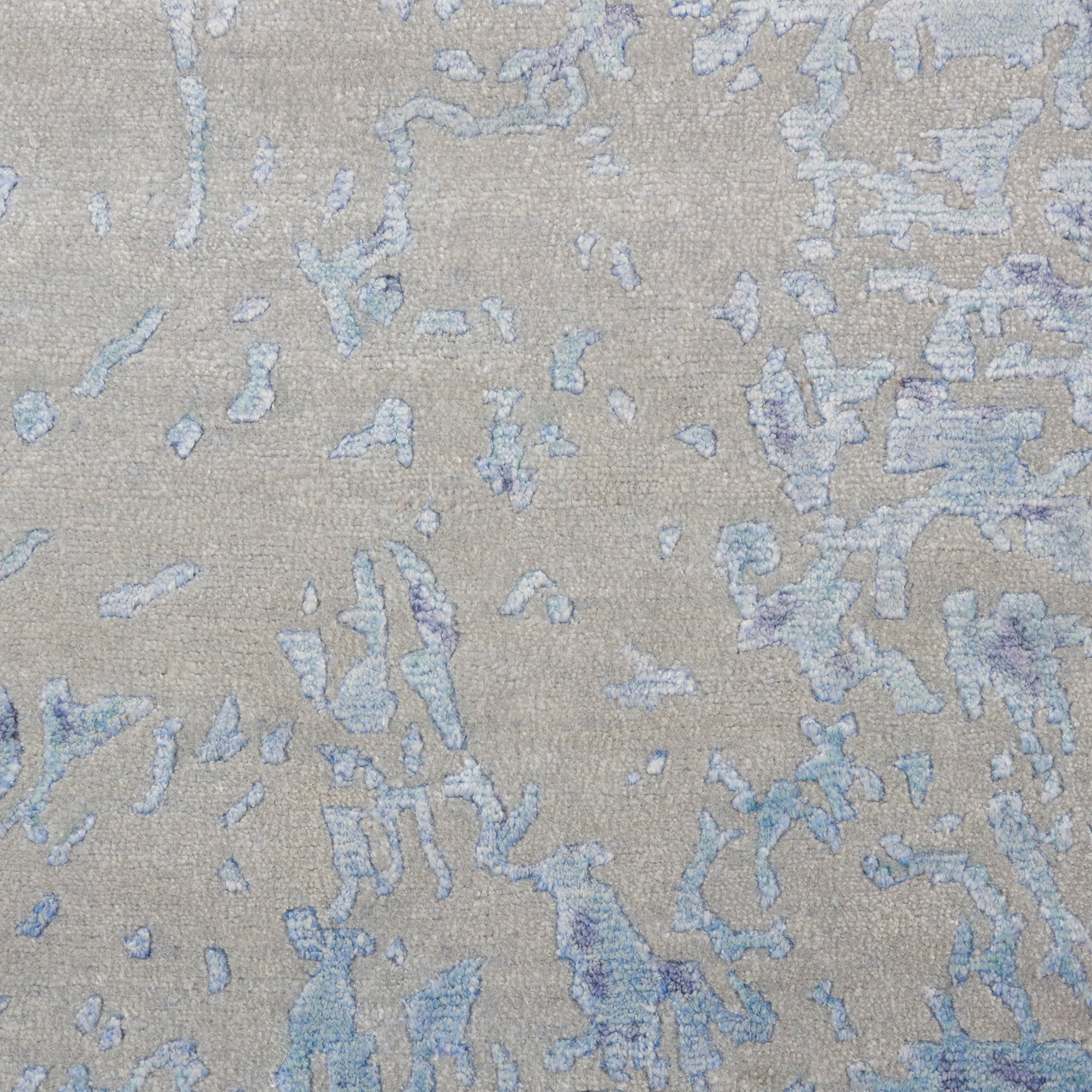 Close-up of textured fabric with abstract blue pattern on neutral base.