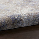 Close-up of a folded area rug with textured design.
