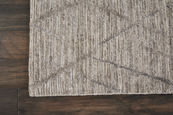 Textured rug with geometric pattern on rustic wooden floor.