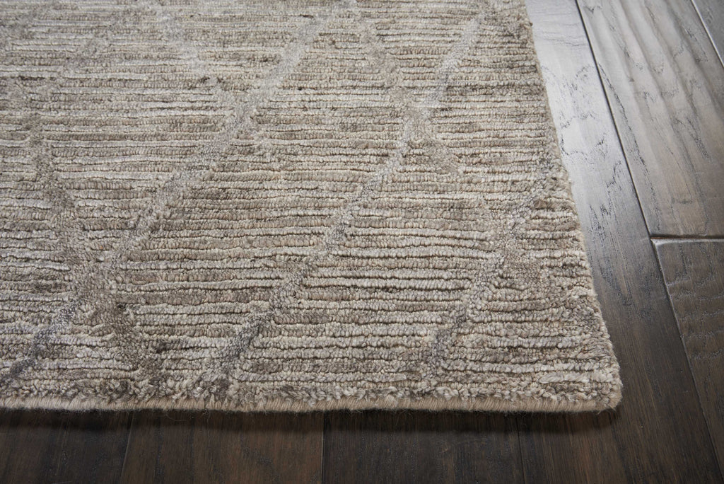 Close-up view of textured area rug on hardwood floor.