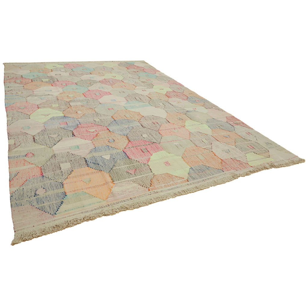Unique handmade rug with hexagonal patchwork pattern, fringed edges, and pastel colors.