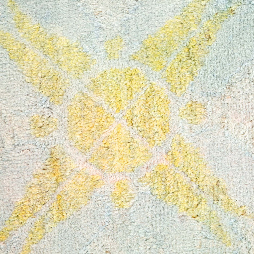 Close-up of a fluffy yellow textured carpet with symmetrical pattern