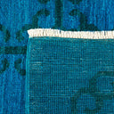 Close-up shot of a vibrant teal textured fabric with fringe.