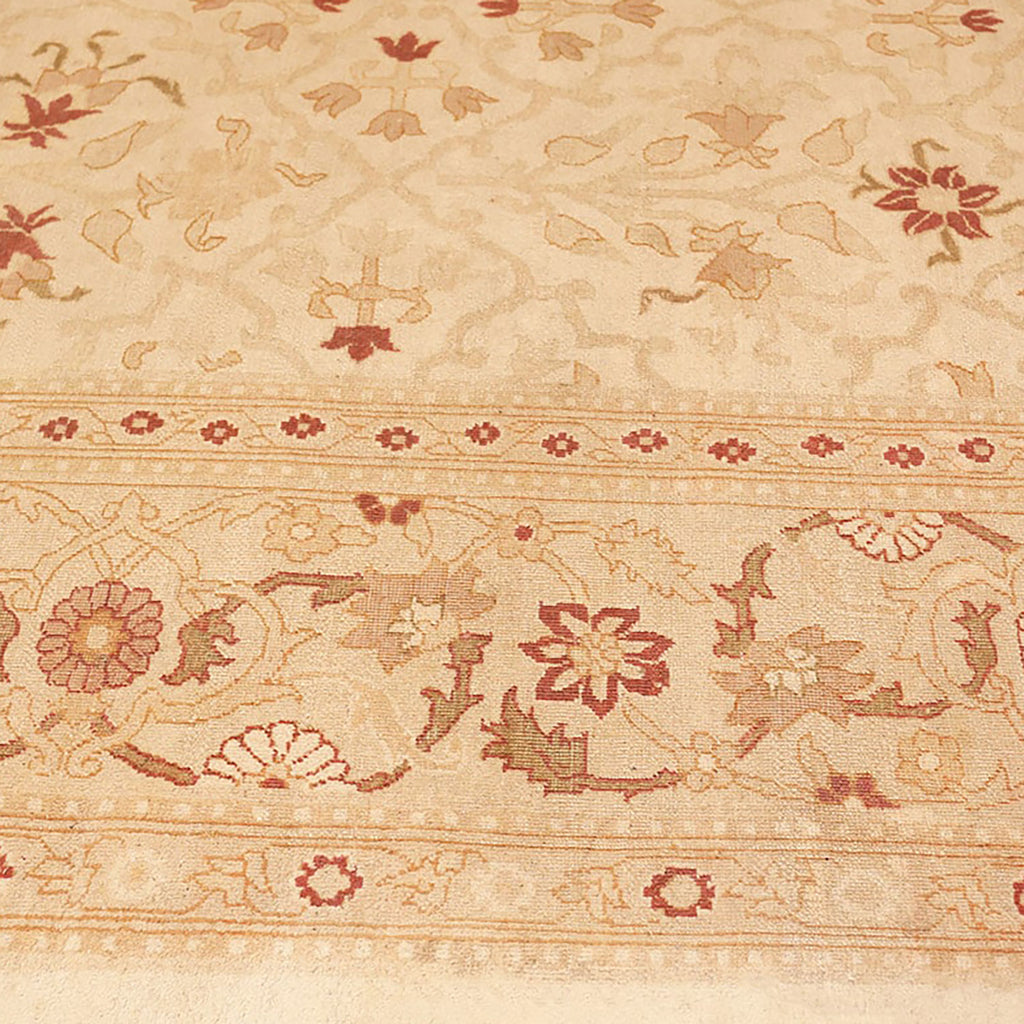 Patterned carpet with floral design and intricate border in muted tones.