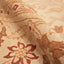 Close-up of a plush, floral patterned carpet in cream and red.