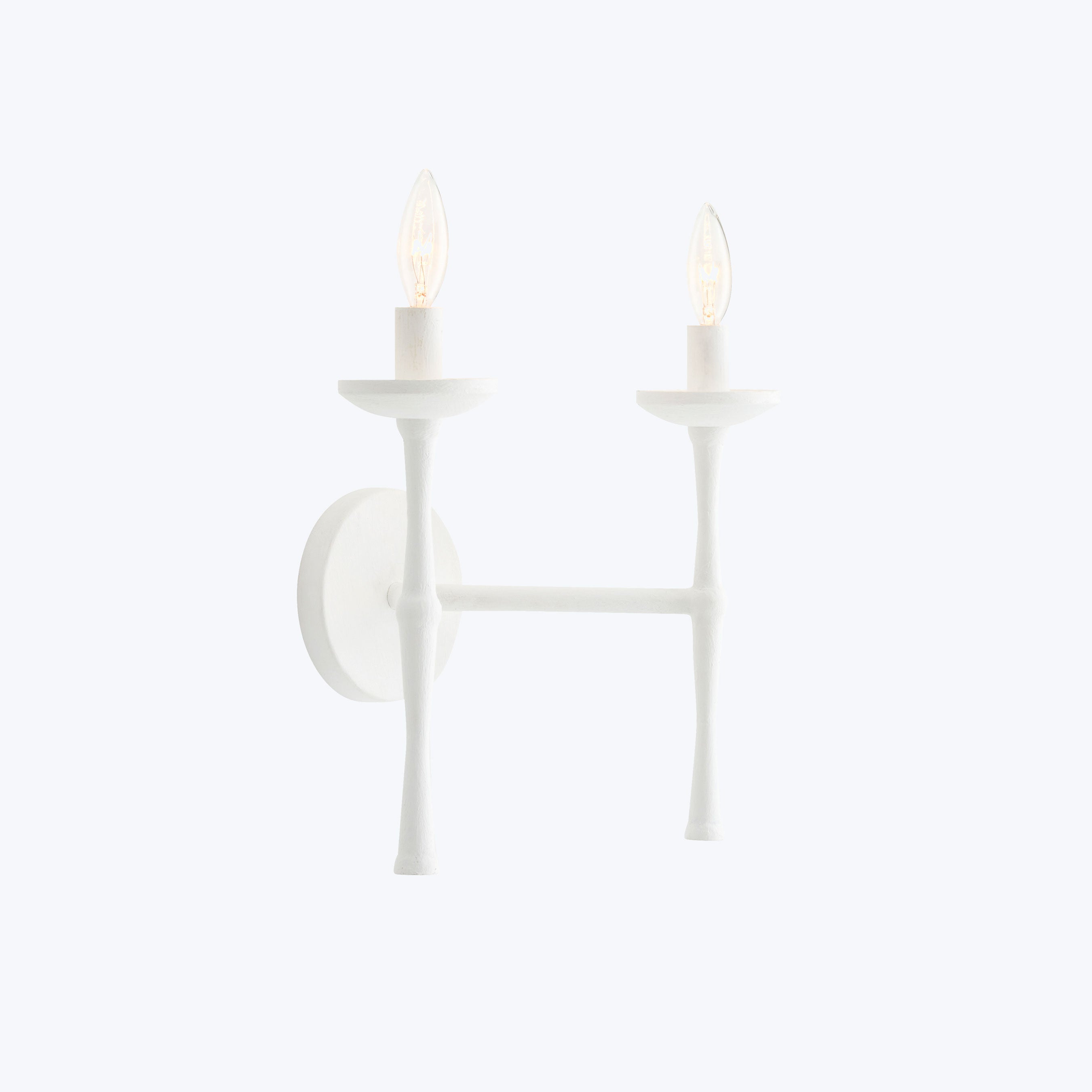 Elegant, minimalist light fixture with elongated flame-shaped bulbs on white wall.
