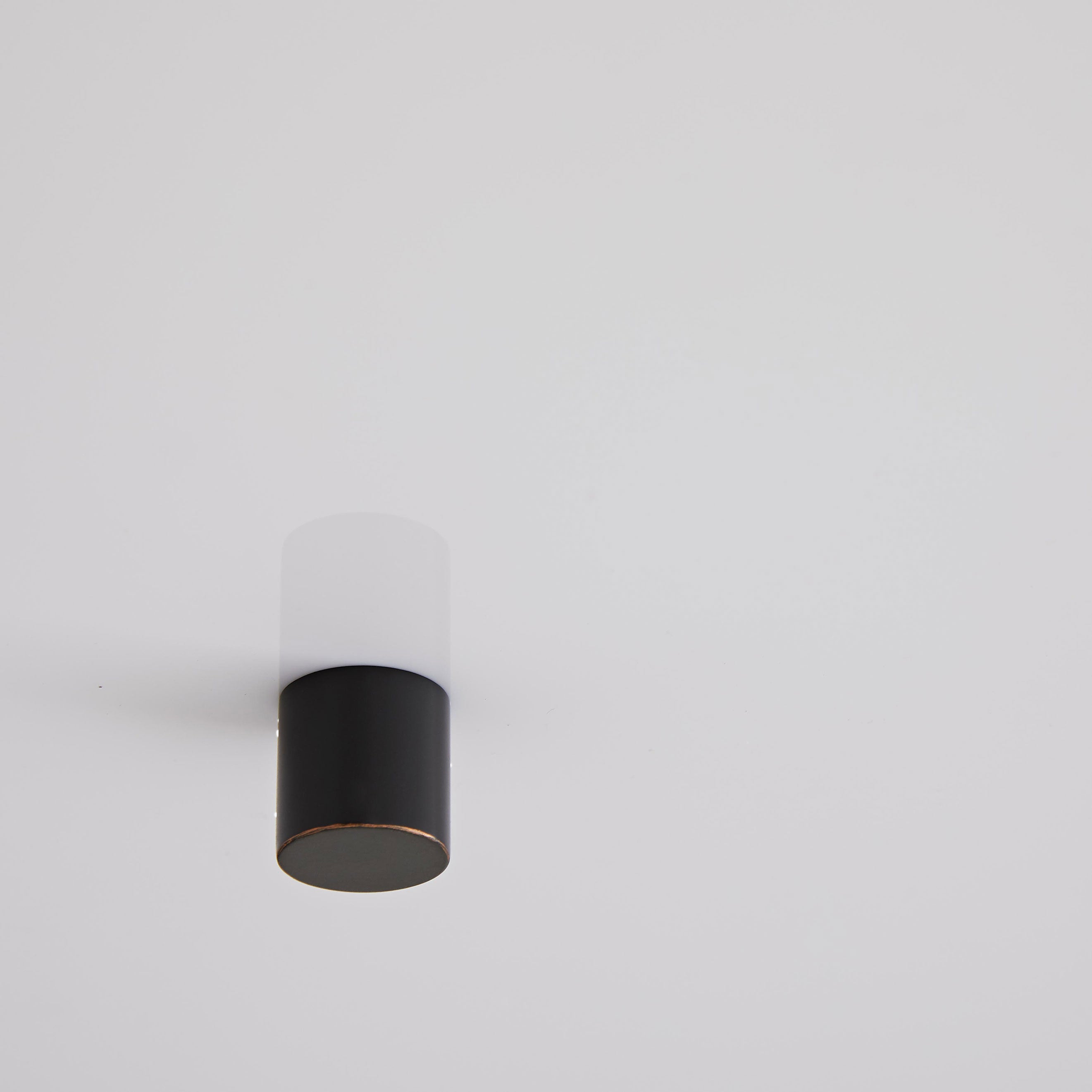 Black and white cylindrical object resembling a modern lamp fixture.