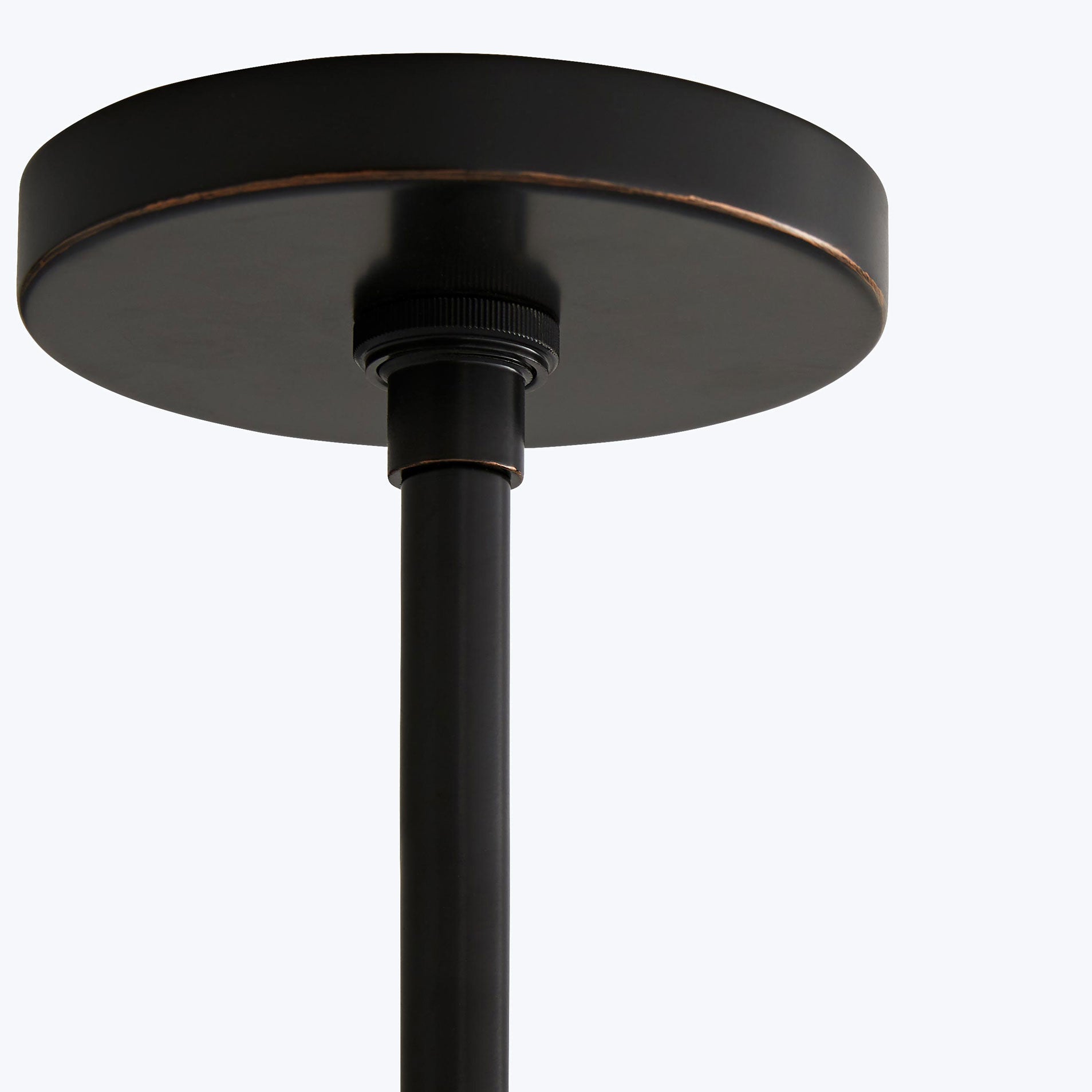 Close-up view of a minimalist black floor lamp with bronze accents.