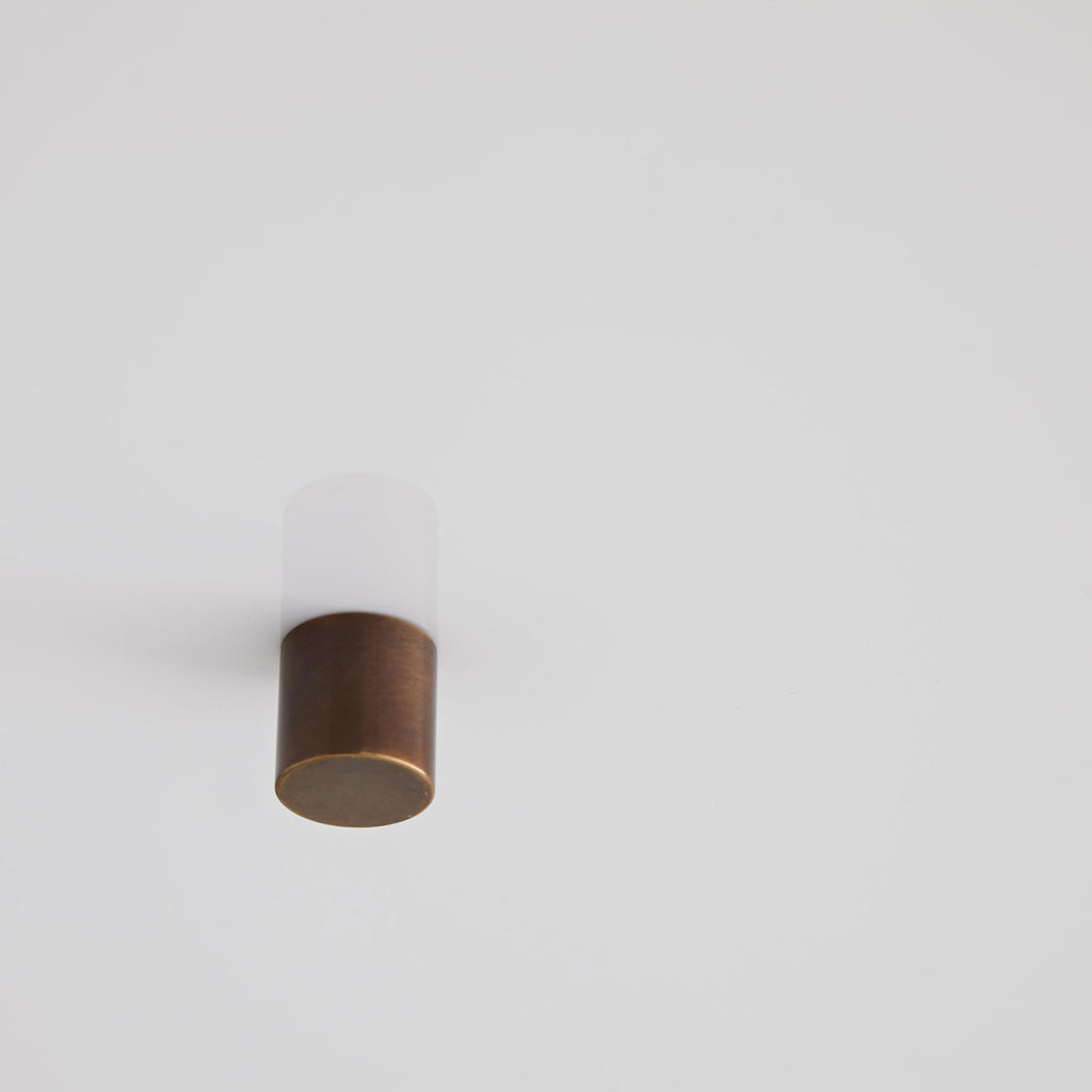 Cylindrical object with transparent top and wooden-like bottom on white background