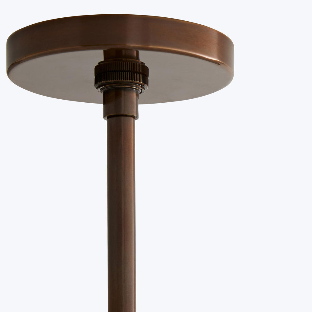 Close-up of a copper-colored lamp stem attached to a ceiling fixture.