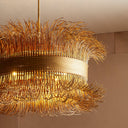 An elegant chandelier with golden rods illuminating a luxurious room.