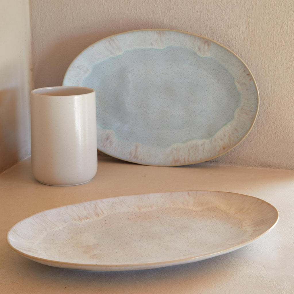 Handcrafted ceramic tableware in rustic style against pale backdrop.