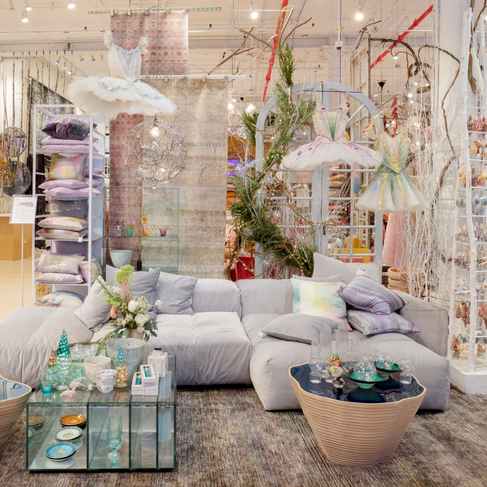 abc storefront with three tutus hanging above grey couch