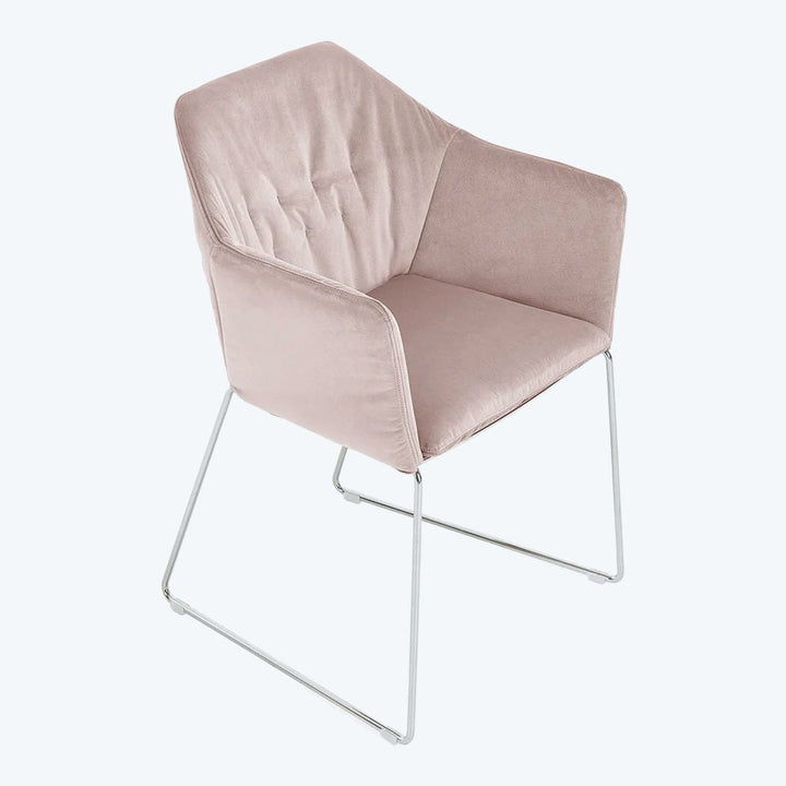 Modern minimalist chair with soft pink upholstery and sleek frame.