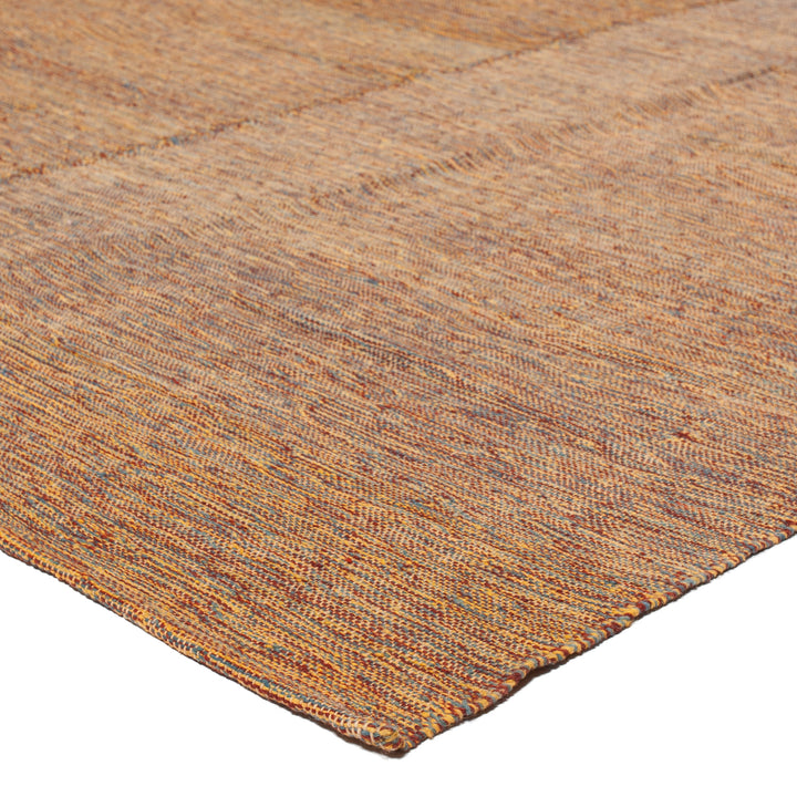 Close-up view of textured, colorful woven rug with warm tones.