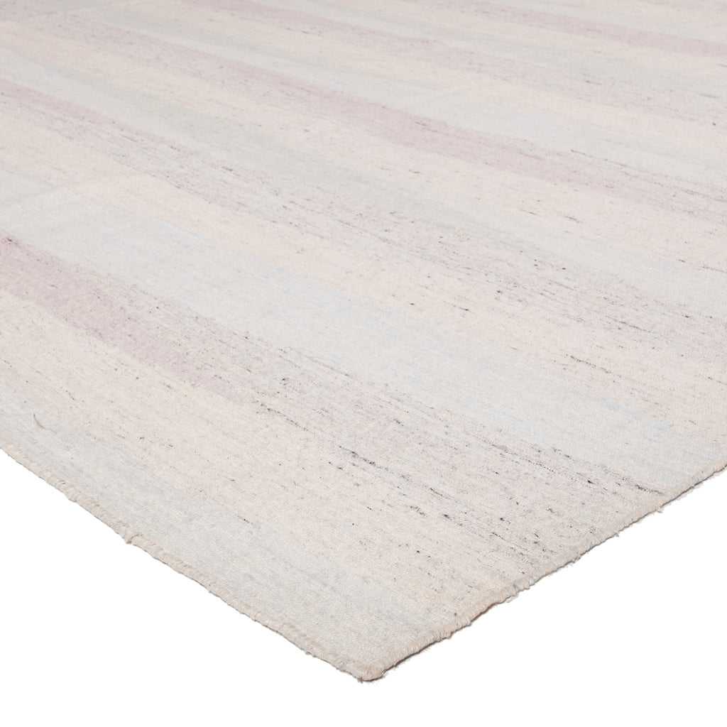 Handmade contemporary rug with soft stripes in muted pastel tones.