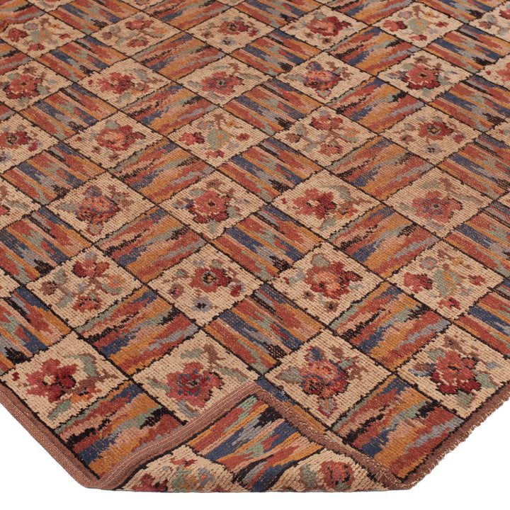 Vintage Persian-style rug with geometric diamond pattern and floral motifs.