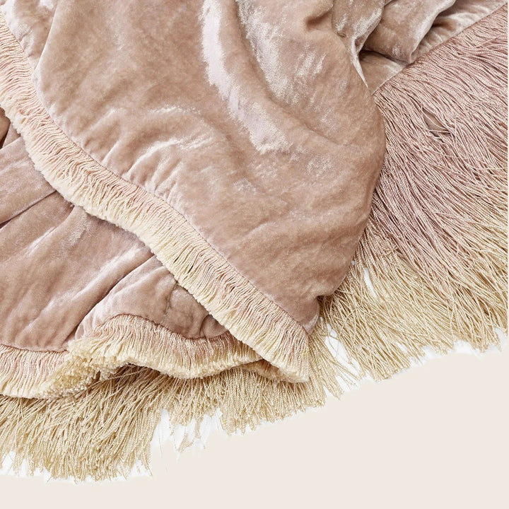 Soft pastel fabric with ombre fringe detail; cozy home decor.