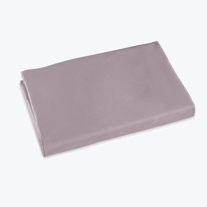 Muted lavender bedsheet folded neatly on white background for retail.