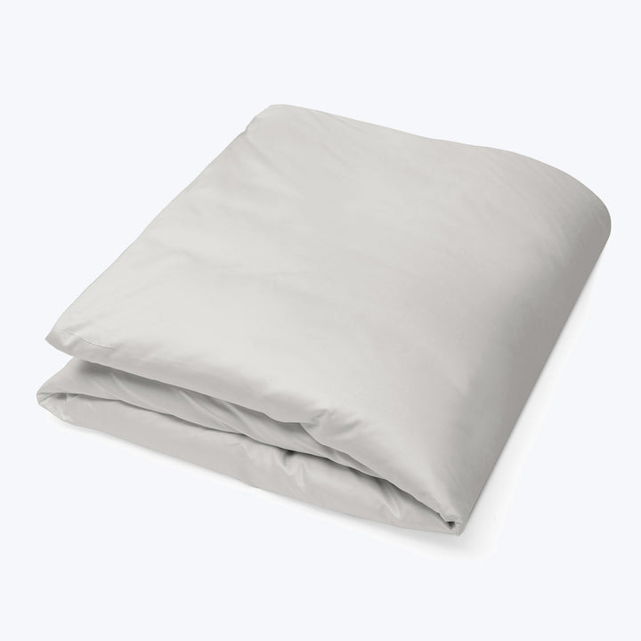 Folded light gray duvet cover on white background, minimalist design.