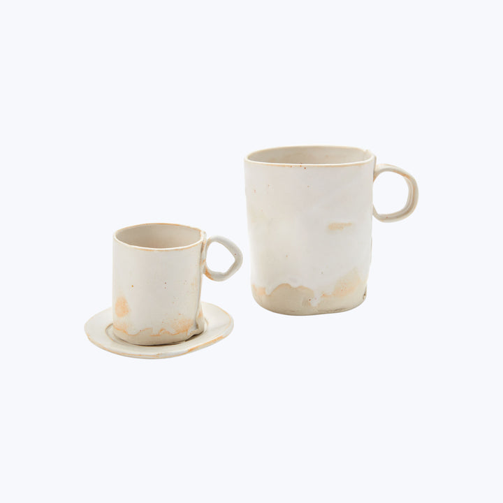 Handcrafted ceramic cup and mug with rustic white design.