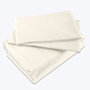 Crisp, clean, and luxurious cream-colored bed sheet set stacked neatly.