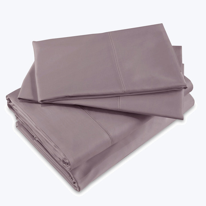Solid color folded bed sheets in soft, wrinkle-resistant fabric.