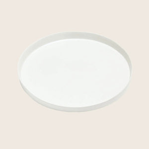 Plain white ceramic plate with raised edge on light background.