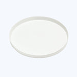Plain white ceramic plate with raised edge on light background.