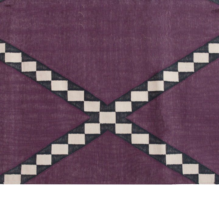 Geometric design textile with checkered pattern in muted purple background.