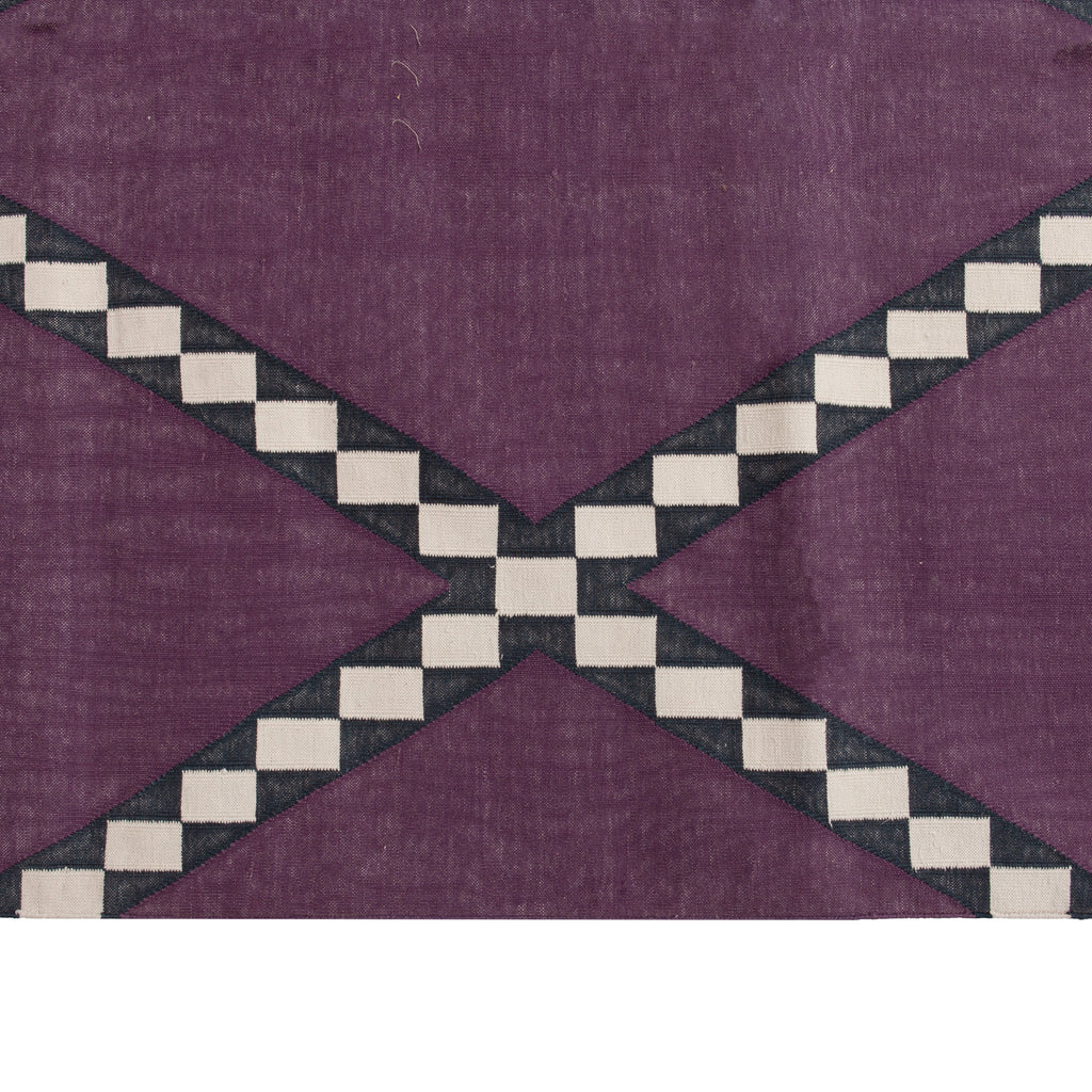 Geometric design textile with checkered pattern in muted purple background.