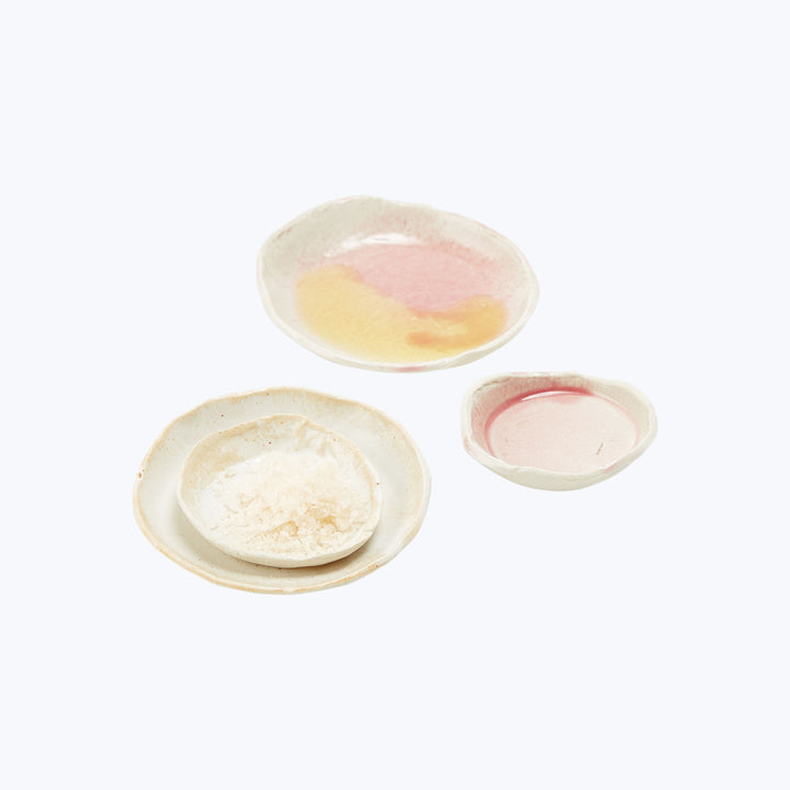 Three ceramic dishes in pastel pink, yellow, cream colors.