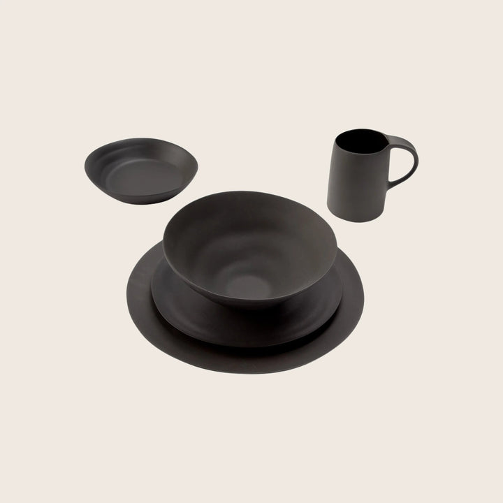 Modern black dining set with elegant design on light background.