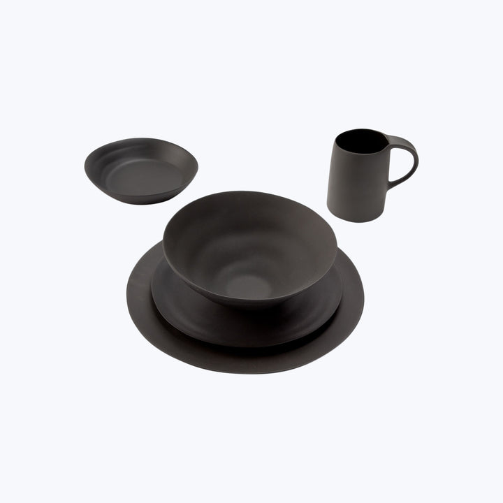 Modern black dining set with elegant design on light background.