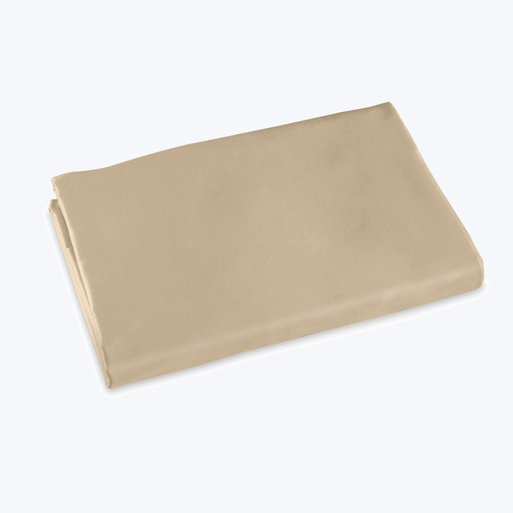 Neatly folded beige fabric against plain background, smooth silky texture.