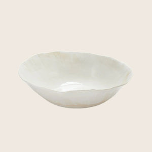 Minimalist white ceramic plate with organic edge profile on display. - hover