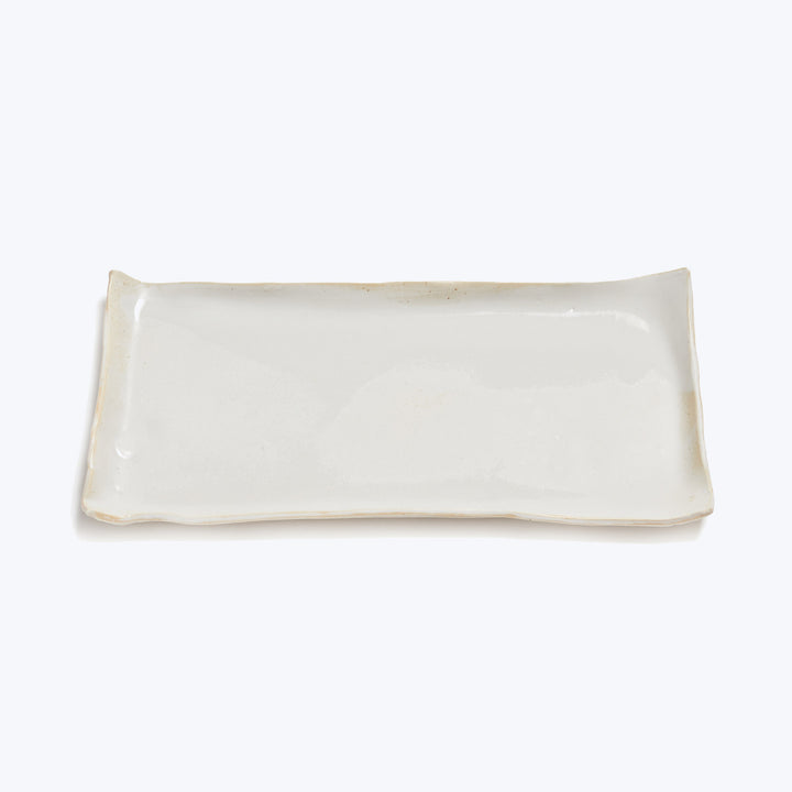 Rectangular ceramic plate with elevated edges for serving food.