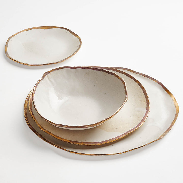 Handmade ceramic dishes with rustic brown rims on plain background.