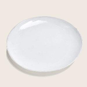 Handcrafted white ceramic dinner plate with rustic texture, empty background. - hover
