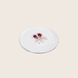 Minimalist round object with delicate pink flower illustration on top - hover