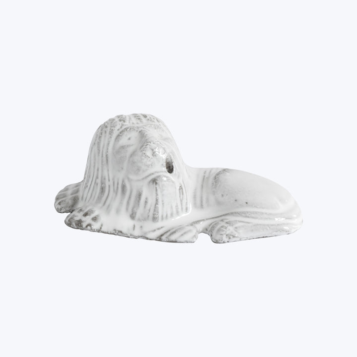 Melted white candle in form of bust head, distorted by heat.