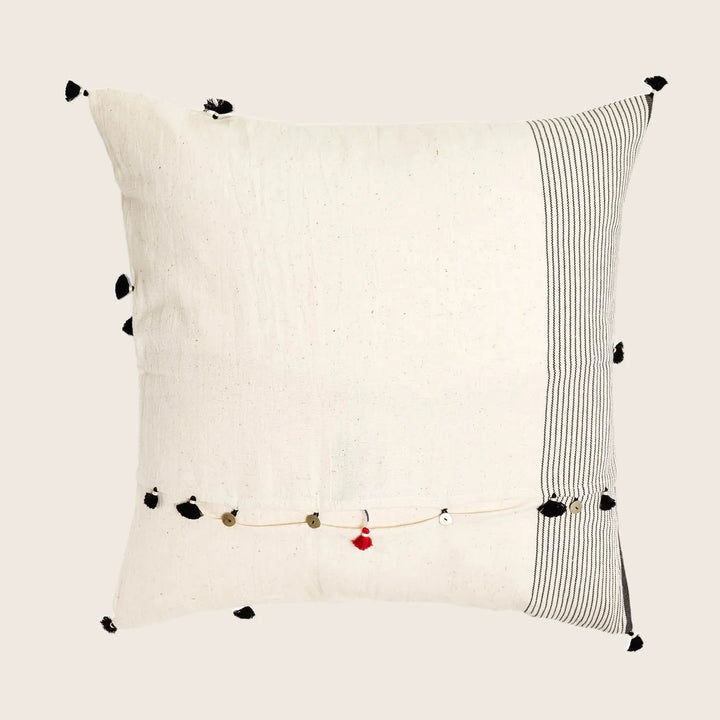 Handcrafted bohemian throw pillow with tassel details and red accent