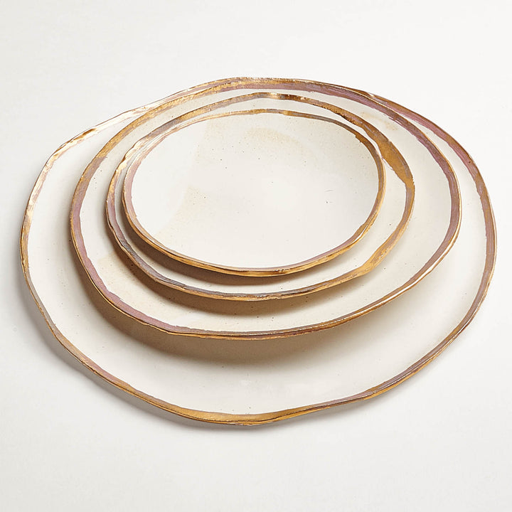 Set of three elegant ceramic plates with metallic rim design.