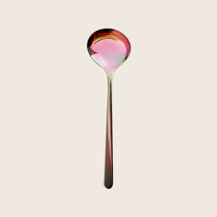 Iridescent spoon reflects rainbow colors against white background, changing hues.