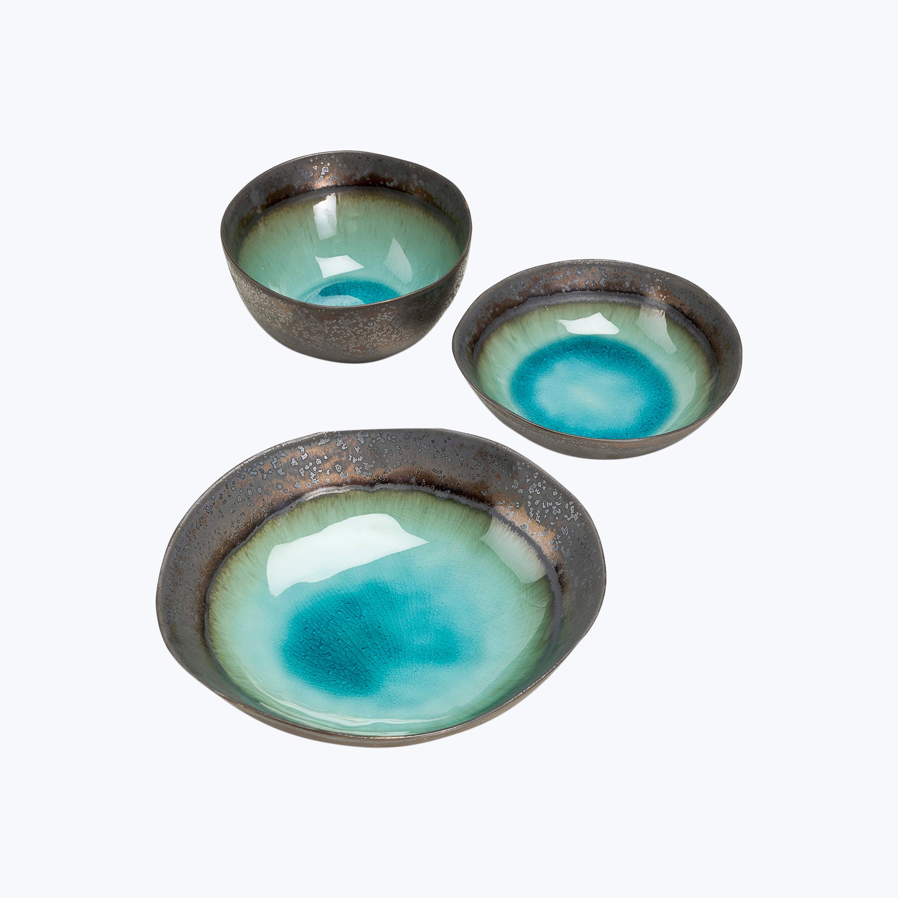 Rustic ceramic bowls with speckled exterior and ombre blue interiors.