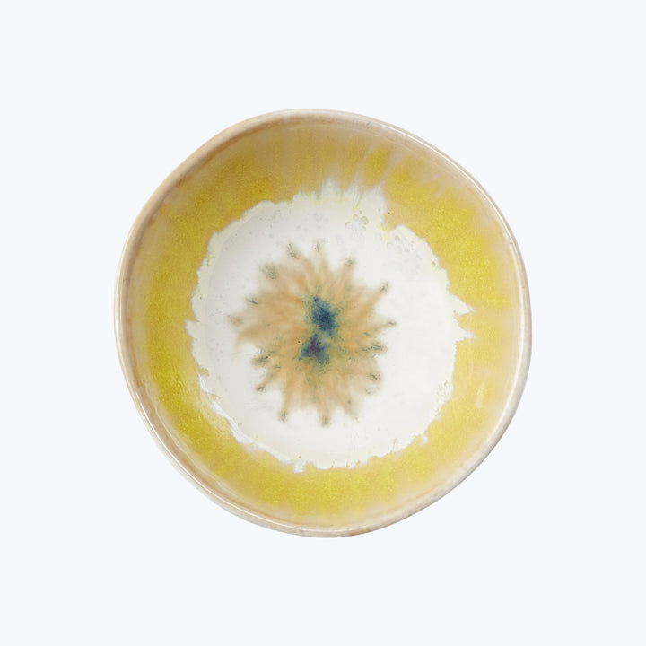 Circular ceramic plate with abstract yellow and blue design pattern.